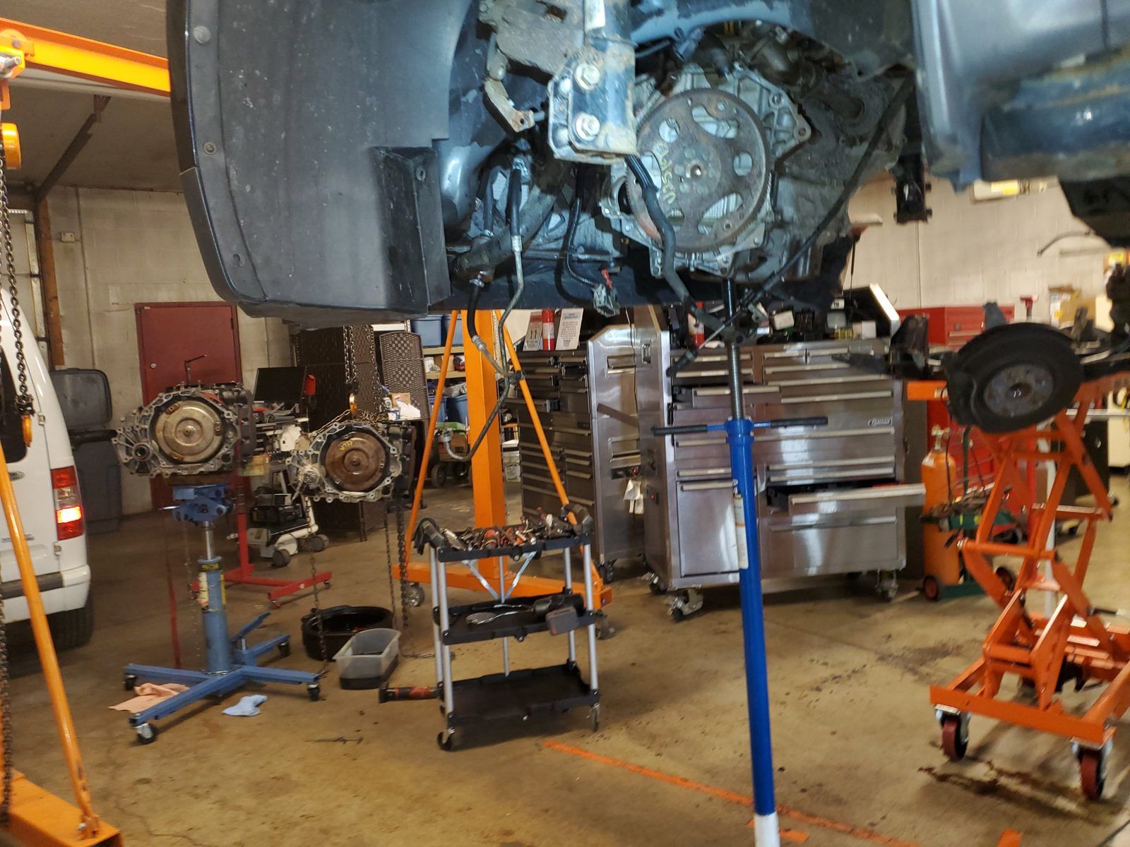 Underside of a raised vehicle with the transmission removed from the engine at Speedy Underhood Service in Columbus, Ohio