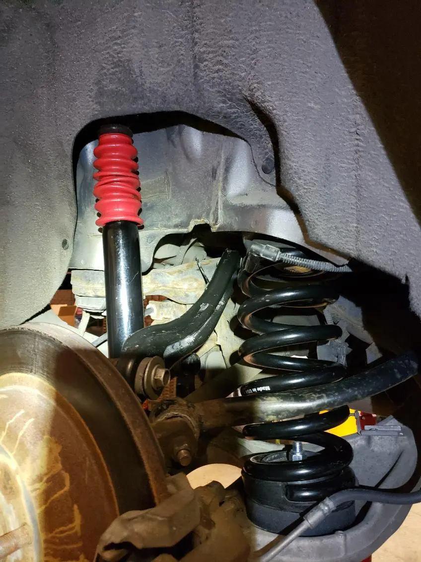 New shock absorber and coil spring fitted in a wheel well during suspension service at Speedy Underhood Service in Columbus, Ohio