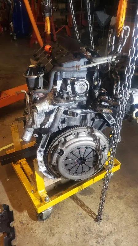 Complete engine assembly with clutch and flywheel exposed on a shop stand at Speedy Underhood Service in Columbus, Ohio