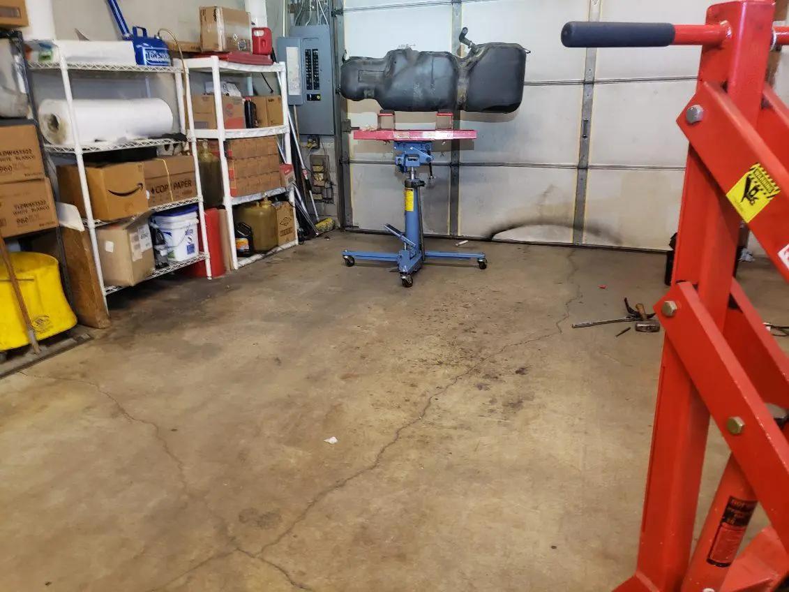 Fuel tank supported on a transmission jack in the service bay during fuel system repair at Speedy Underhood Service in Columbus, Ohio