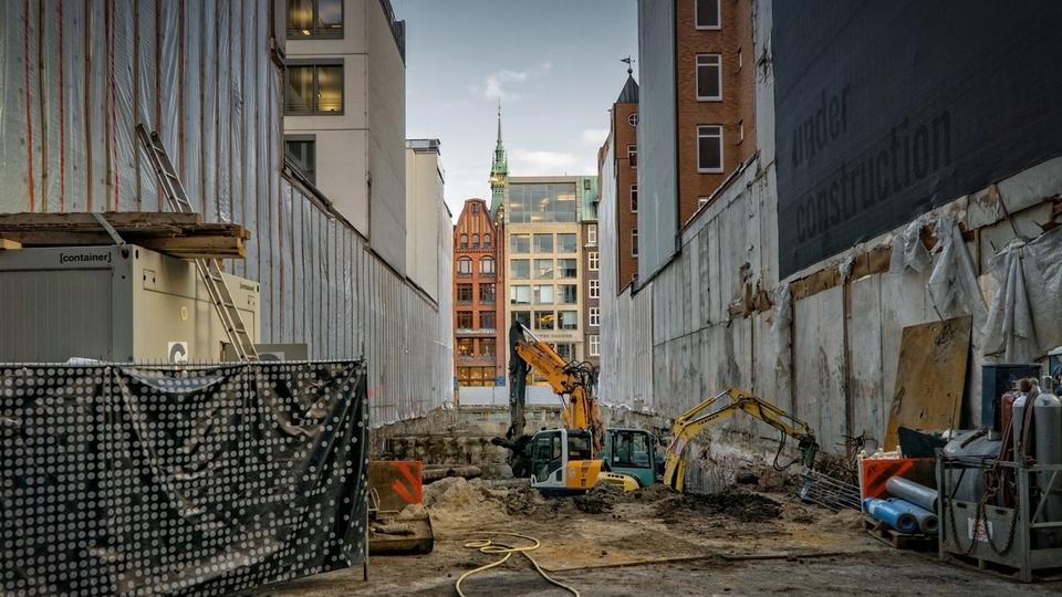 Civil construction site in a city with an excavator in a pit