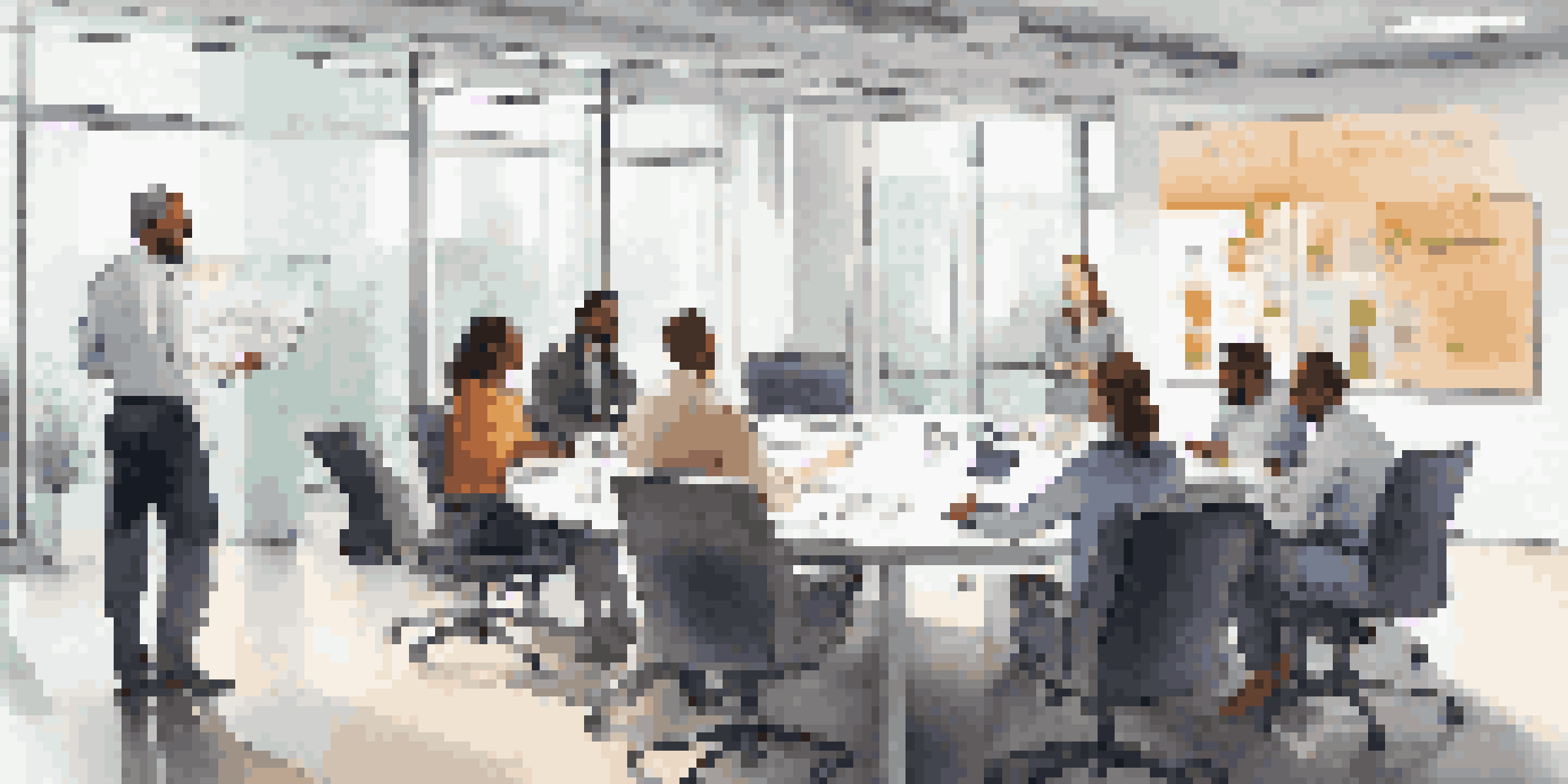 A diverse group of employees having a discussion in a well-lit conference room with motivational posters on the walls.