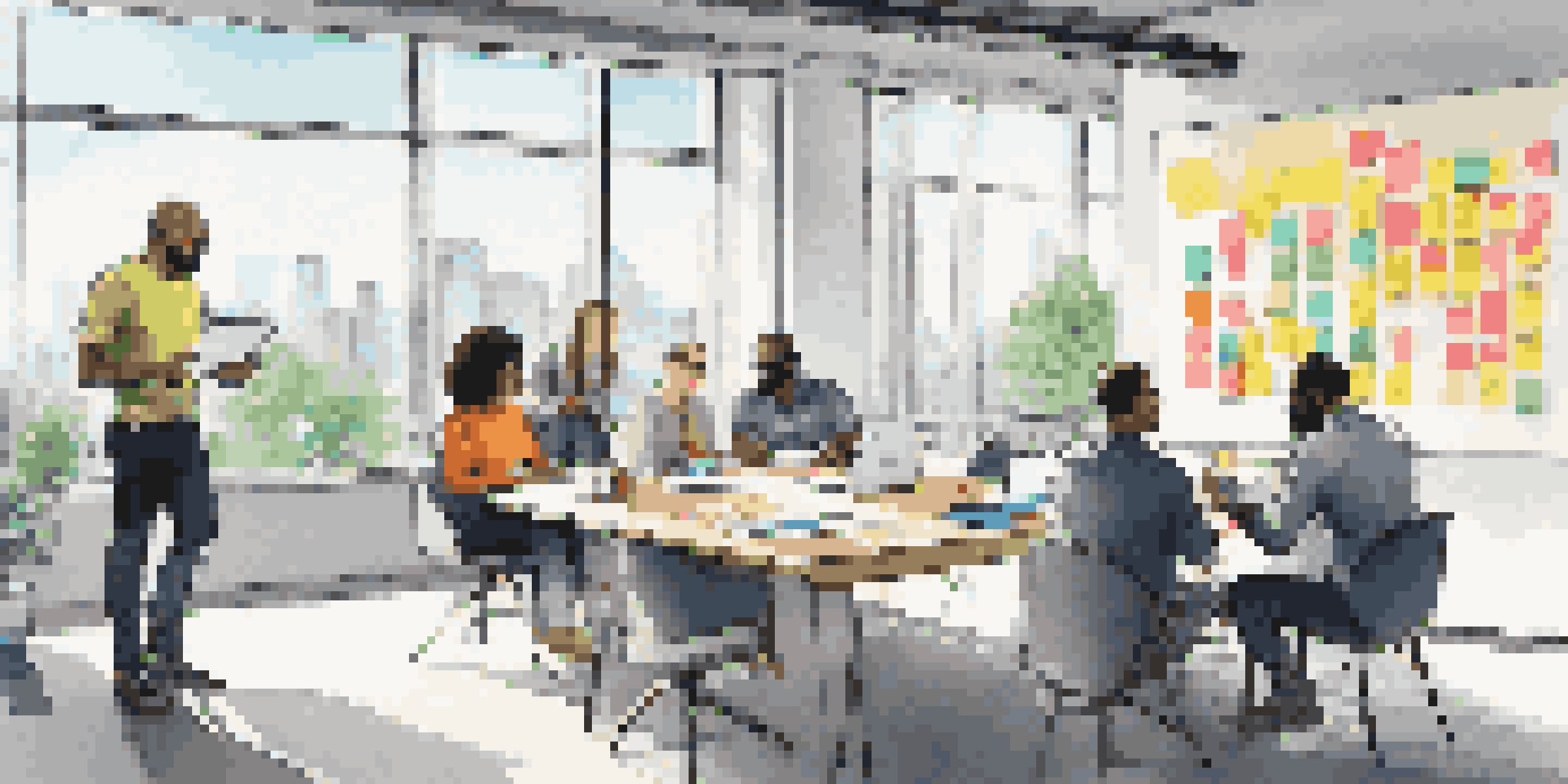 A diverse team brainstorming in a modern office with large windows and a city view.