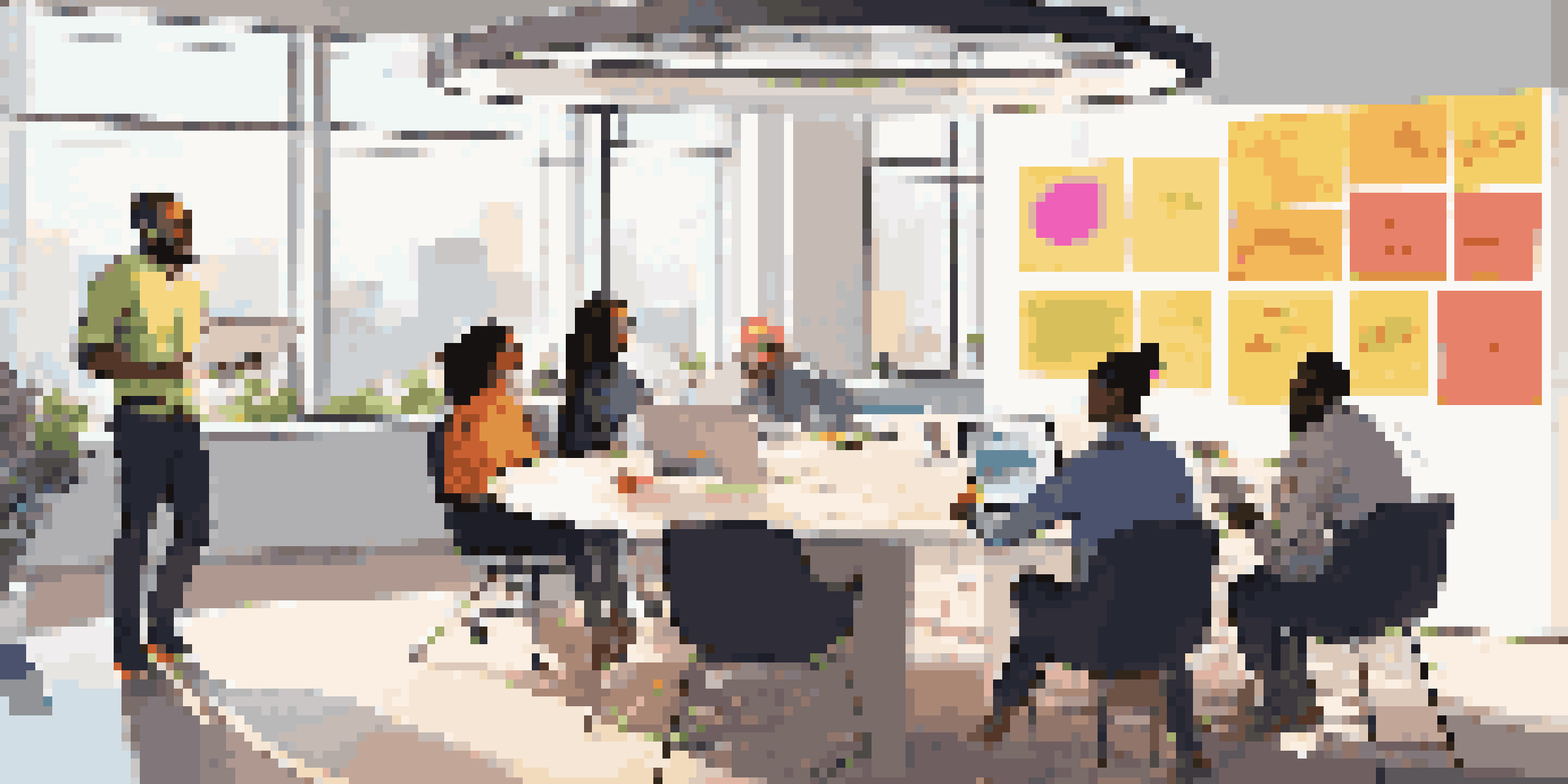 A diverse group of professionals collaborating in a modern office, discussing around a circular table with laptops and colorful notes.