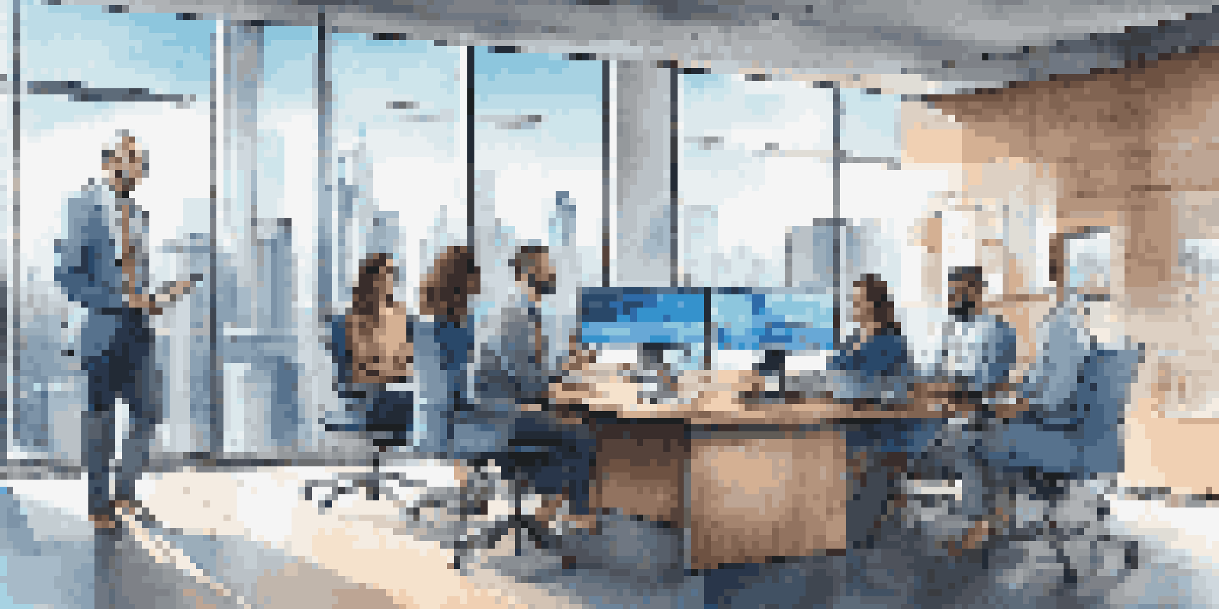 A diverse team of sales professionals working together in a bright office, with laptops and screens showing data analytics.