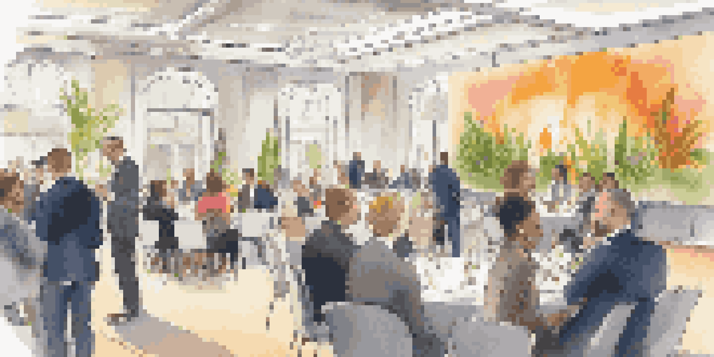 A diverse group of professionals engaging in conversation at a networking event in an elegant conference hall.