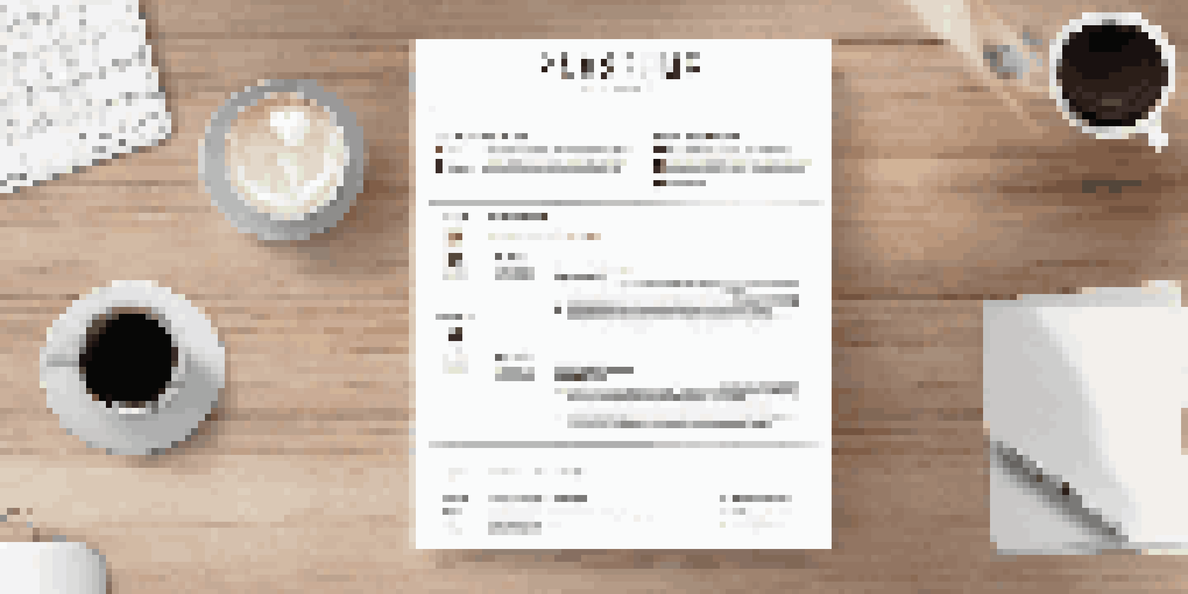 A clean and organized resume on a wooden desk next to a laptop and a coffee cup, with natural light coming through a window.