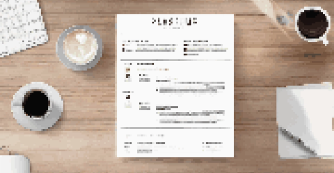 A clean and organized resume on a wooden desk next to a laptop and a coffee cup, with natural light coming through a window.