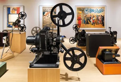 A group of old projectors are sitting on display in a museum