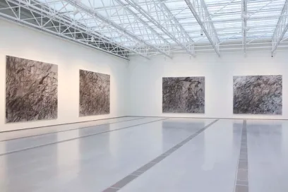 A large empty room with four paintings on the wall