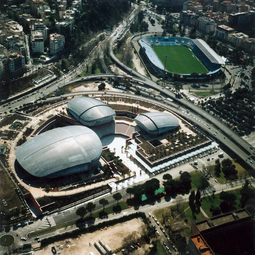 An aerial view of a city with a stadium in the background