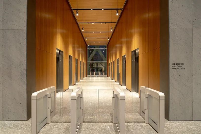 A long hallway with elevators and gates in a building