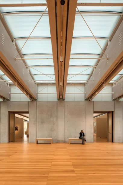 A man sits on a bench in an empty building