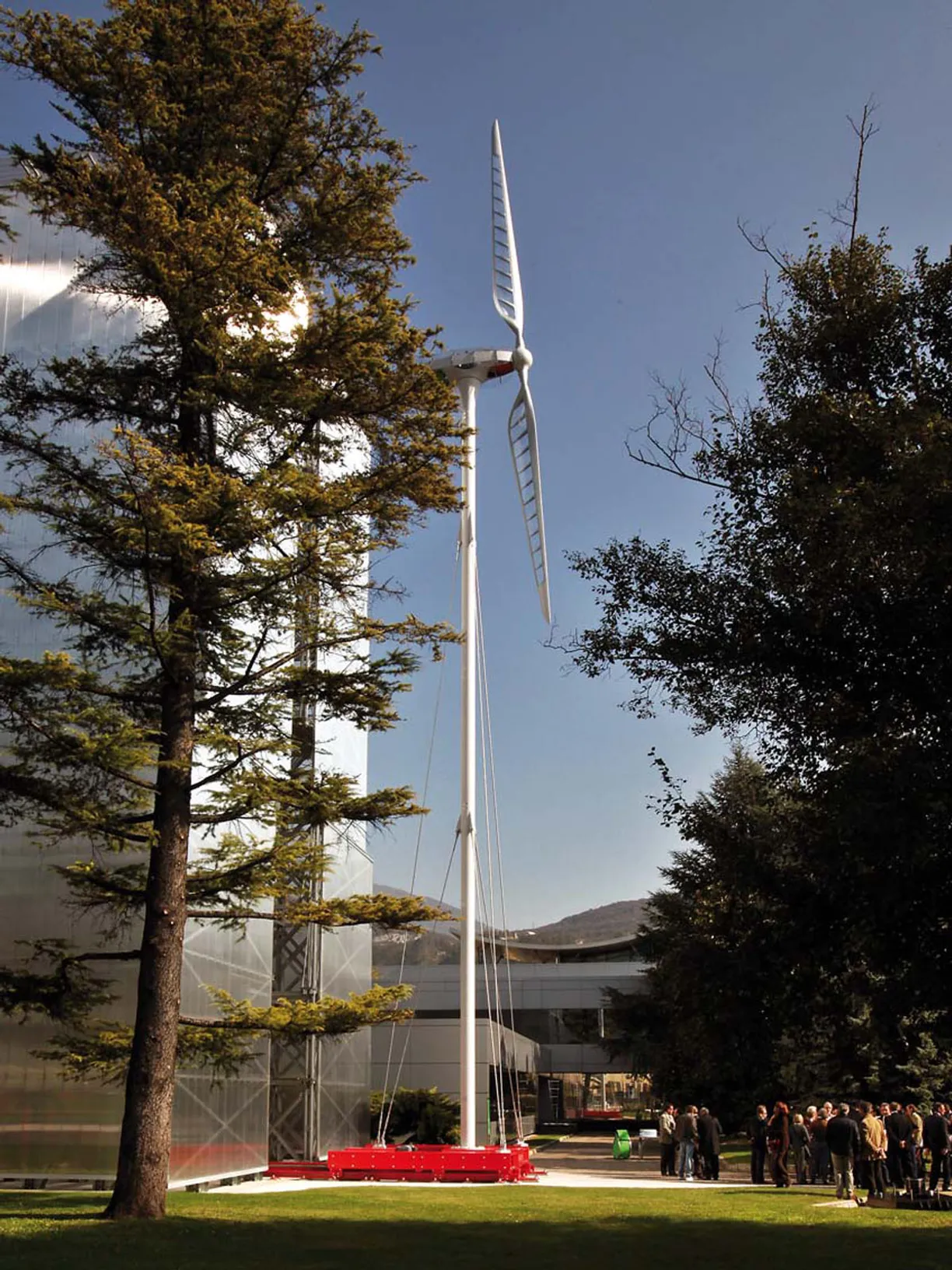 a group of people standing in front of a large wind turbine