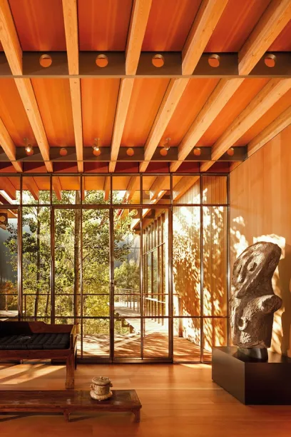 A living room with a wooden ceiling and lots of windows