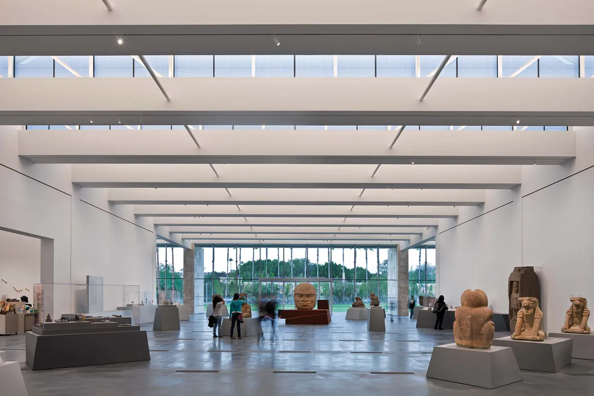 A group of people are looking at sculptures in a museum