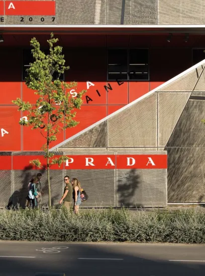 two boats are docked in front of a large building in a harbor .