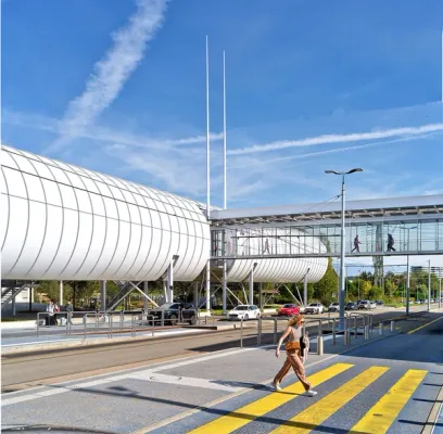 A woman is crossing a street in front of a building