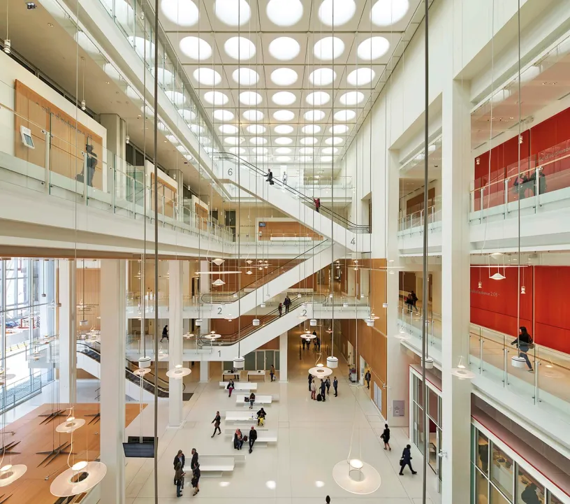 A large building with a lot of windows and people walking around it