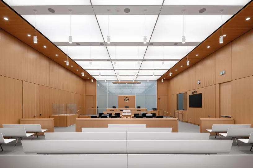 A large courtroom with wooden walls and a white ceiling