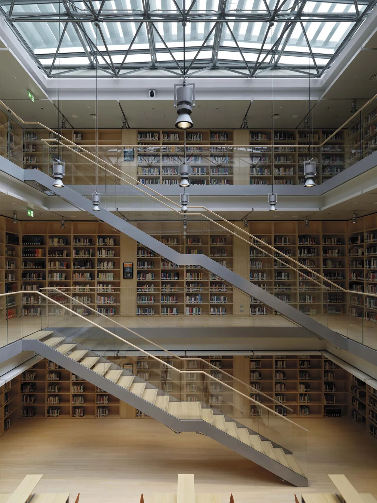 a library with stairs leading up to the second floor