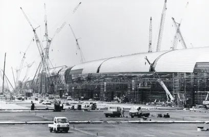 a black and white photo of a large building under construction .