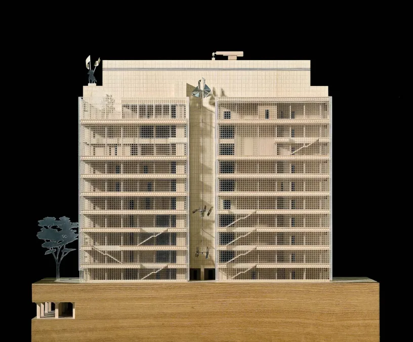 A model of a building with a tree in front of it on a black background