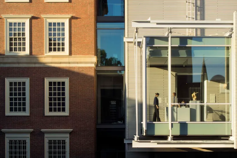 A man is standing on a balcony in front of a building