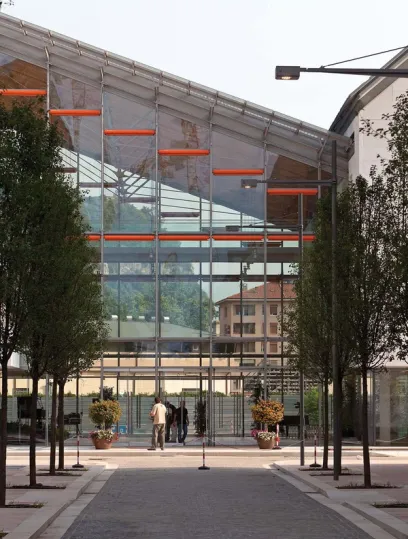 people walking in front of a large glass building