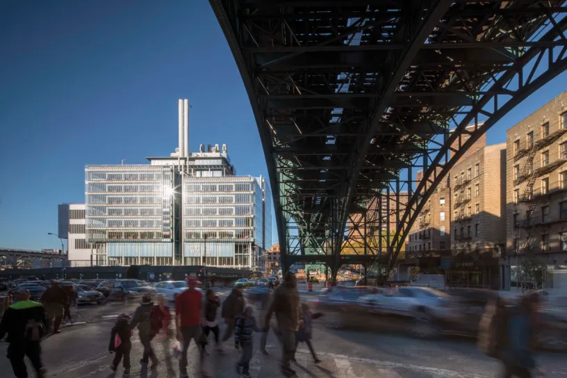 a group of people are walking under a bridge in a city .