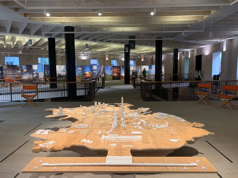 a large wooden model of a city is sitting on a table in a museum .