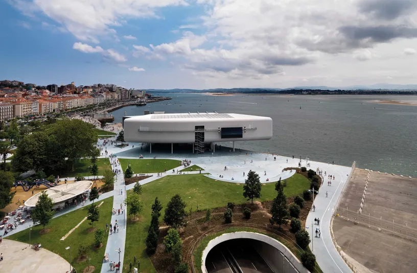 An aerial view of a large white building next to a body of water