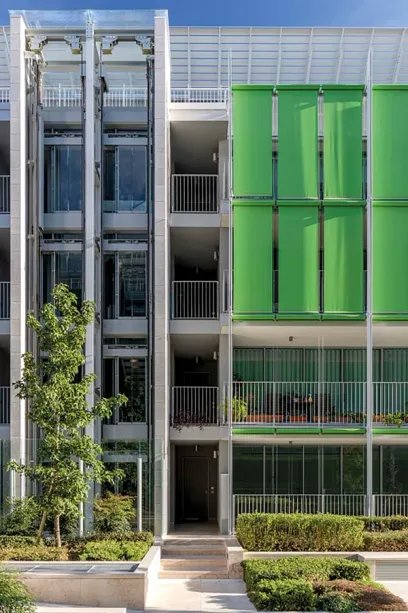 A building with a lot of windows and green blinds on the windows