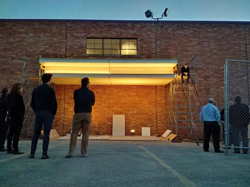 A group of people are standing in front of a brick building