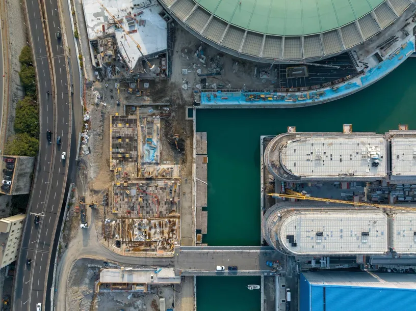 An aerial view of a construction site next to a body of water