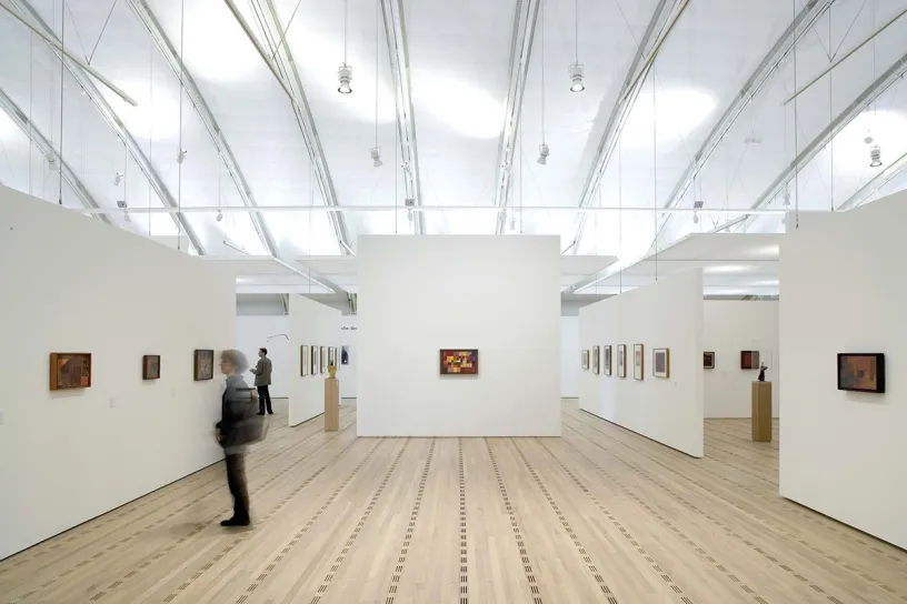 A man is looking at a painting in a museum