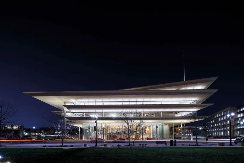 A large building with a lot of windows is lit up at night