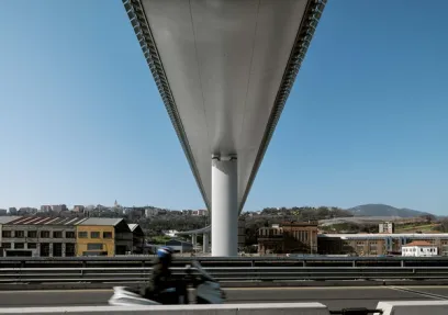 A person is riding a motorcycle under a bridge