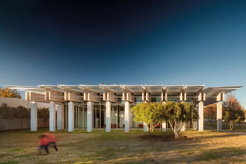 A person is walking in front of a large building