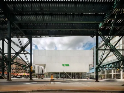 a building with a green sign on it is under a bridge .