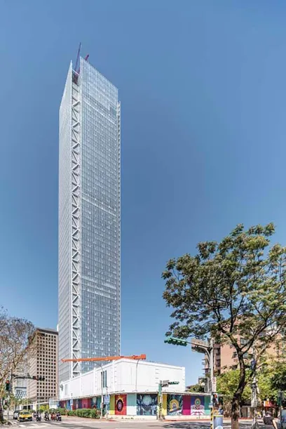 A very tall building is being built in the middle of a city