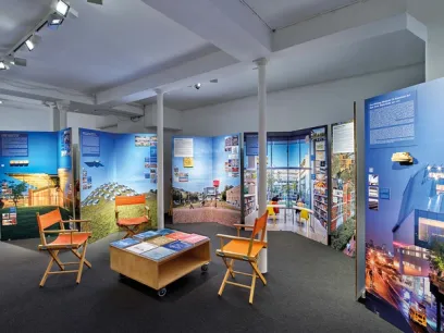 A room with a table , chairs , and posters on the wall