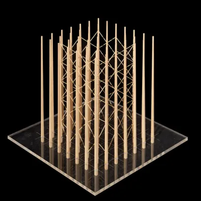 a model of a building made of wooden sticks on a clear acrylic plate .