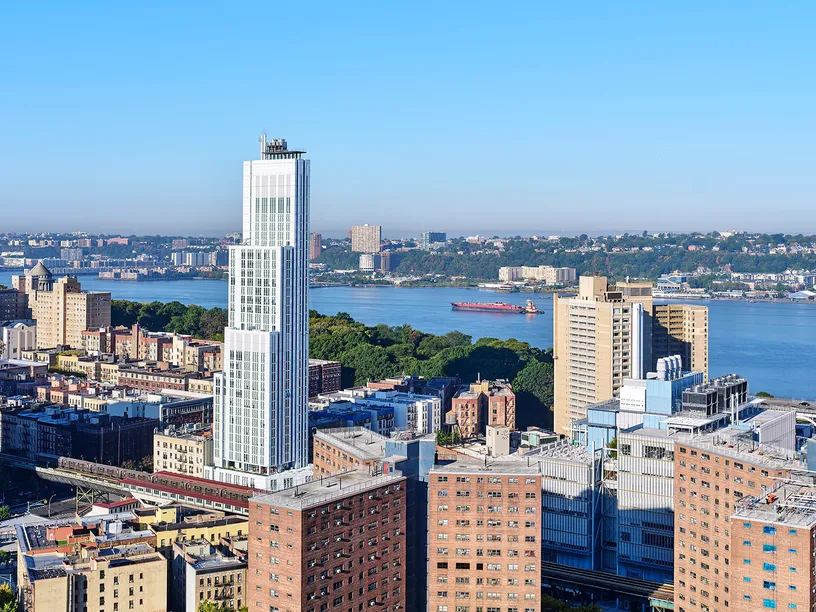 a group of people are walking down a sidewalk in front of a large building .