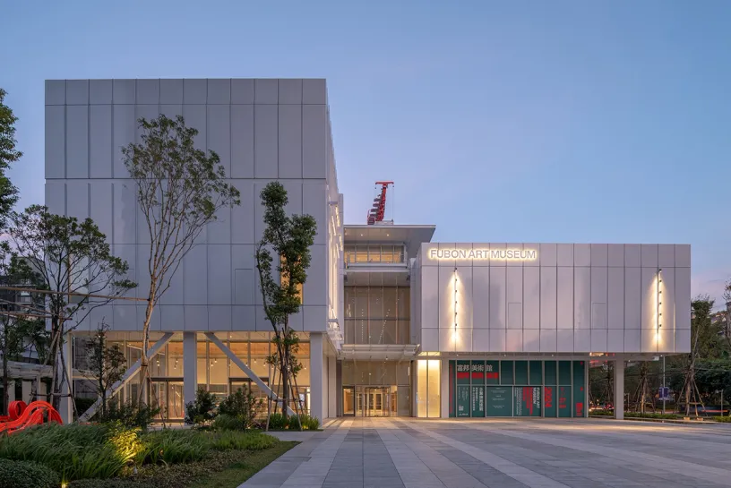A large white building with a lot of windows and trees in front of it