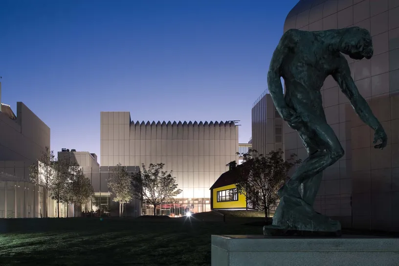 A statue of a man standing in front of a building at night