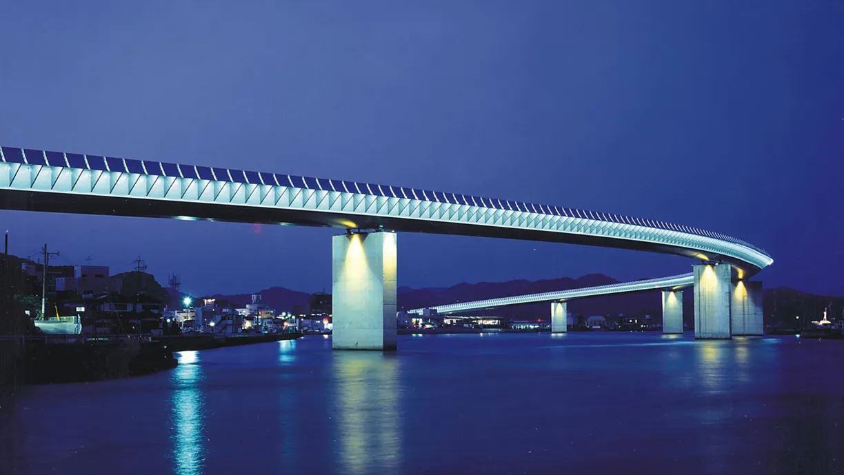 a person riding a scooter under a bridge