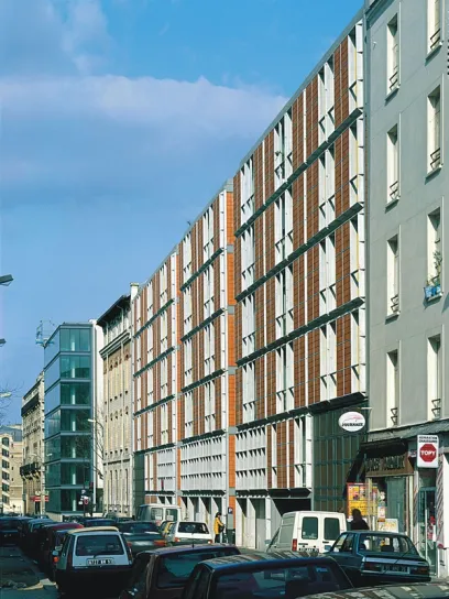 a row of cars are parked in front of a building with a sign on the side that says ' coca-cola '