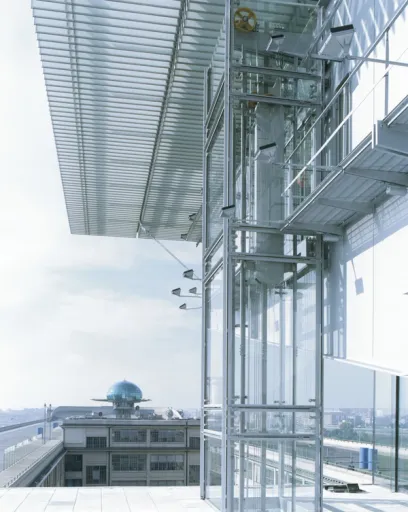 A very tall building with a glass facade and a very large dome in the background
