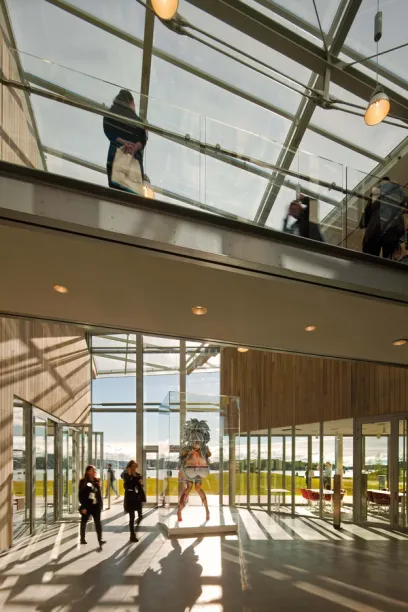 A group of people are walking through a building with a glass roof